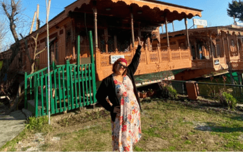Houseboat Kashmir mengapung di Danau Dal dengan latar pegunungan Himalaya